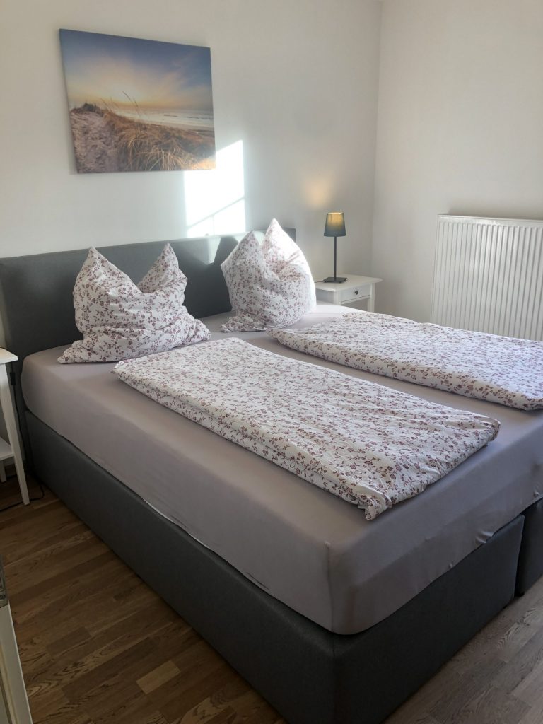 Doppelbett mit Blumenbettwäsche